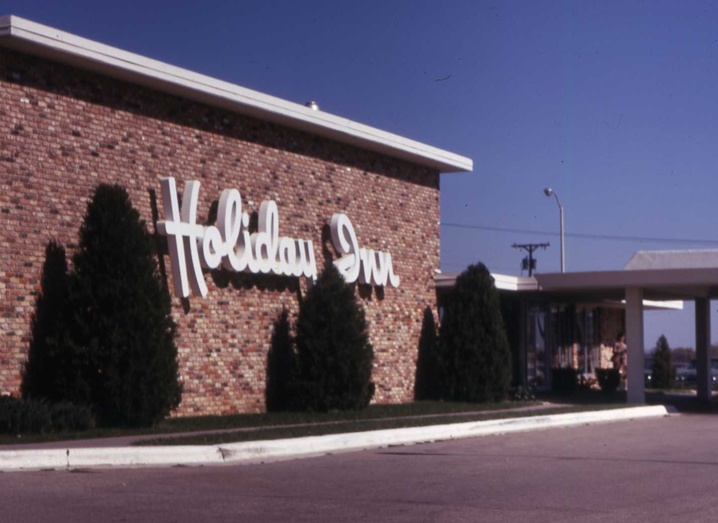 Holiday Inn sign on the side of a brick Holiday Inn hotel.